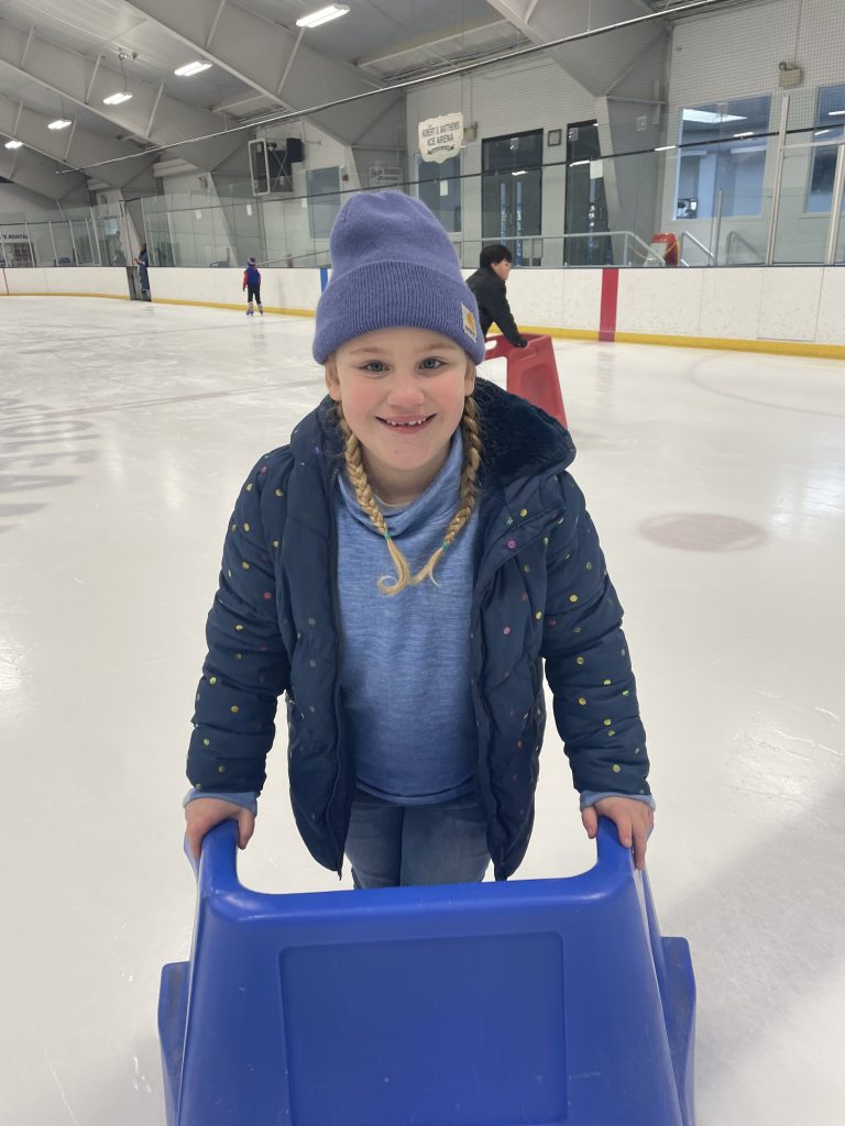 student smiles while ice skating