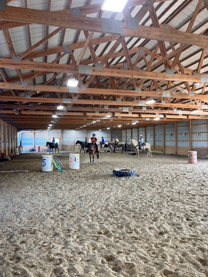 Fillmore Youth students riding horses in indoor arena