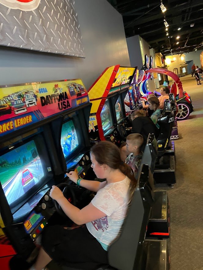 students racing cars at arcade