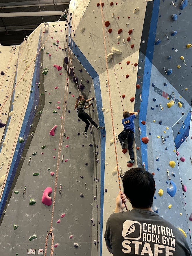 student scaling rock wall