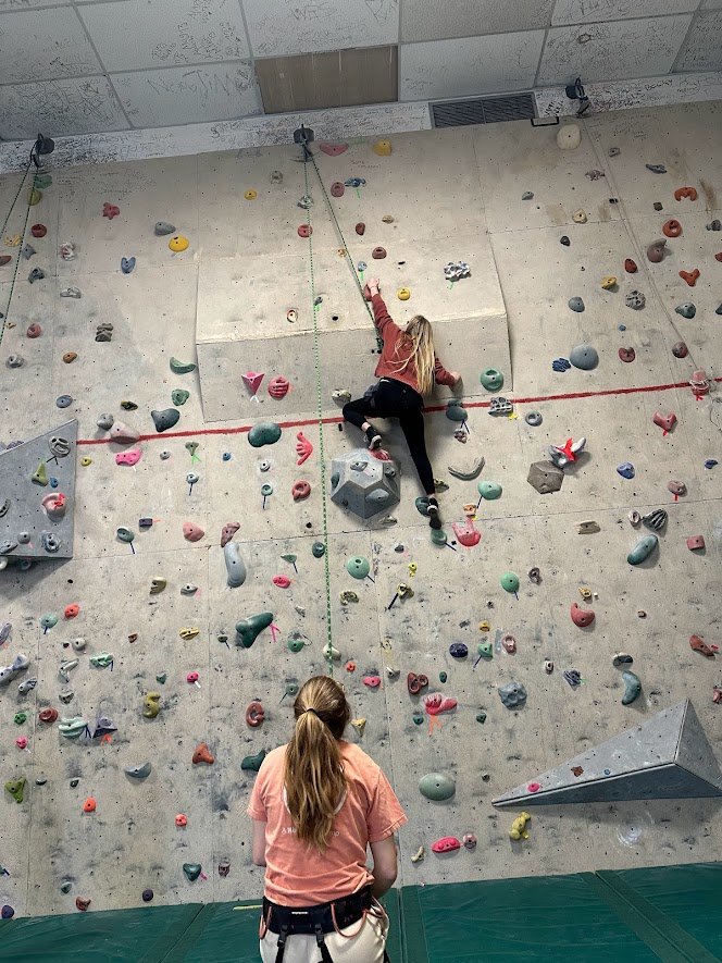 student climbs rock wall