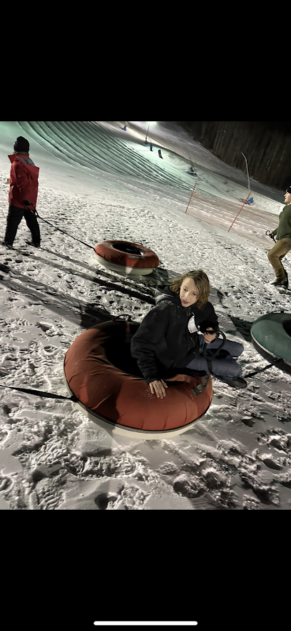 student sits in snow tube