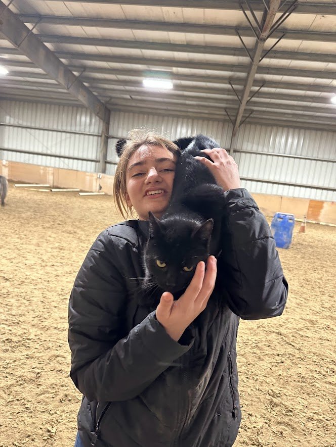 student holds black cat